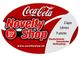 Coca-Cola Novelty Shop Logo, rotes Oval mit Text: Caps, Uhren, T-Shirts, und Website-Link.