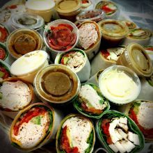 Assorted wraps with various fillings and dips arranged on a platter.