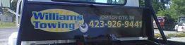 Towing truck sign for "Williams Towing" with phone number in Johnson City, TN.