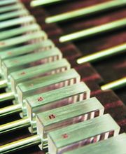 Conjunto de bloques metálicos numerados en fila sobre una superficie oscura.