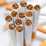 Close-up of a group of cigarette ends arranged in a circular pattern, viewed from above.