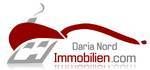 Logo von Daria Nord Immobilien mit rotem Dach und rauchendem Schornstein.