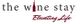 Logo: "The Wine Stay" with a bottle as the "i" and the slogan "Elevating Life" below.