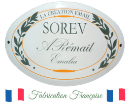 Plaque ovale "SOREV", texte en français, entourée de branches, drapeaux français en bas.