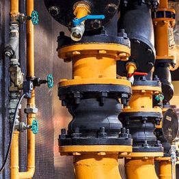 Yellow and black industrial pipes with valves and connectors.