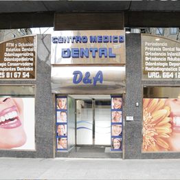 Fachada de centro médico dental con carteles y fotos de sonrisas.