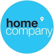 Blaues Logo mit der Aufschrift "home company" und einem kleinen Ortsmarker oben rechts.