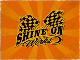 Text "Shine On Works!" mit Rennflaggen auf orangefarbenem Hintergrund mit Strahlenmuster.