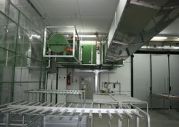 Interno di una sala macchine con tubature e attrezzature industriali in metallo.