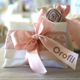 Cuscino decorativo con fiocco rosa e fiore beige, etichetta "Orofil".