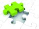 Grünes Puzzleteil schwebt über weißem Puzzle mit leerer Stelle.