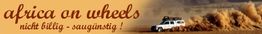 Ein weißer Geländewagen fährt durch Sand, daneben steht "africa on wheels" und "nicht billig - saugünstig".