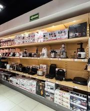 Estantes con electrodomésticos de cocina en una tienda, como licuadoras y tostadoras.