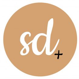 Brauner Kreis mit weißem "sd" und schwarzem Pluszeichen.