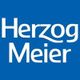 Herzog Meier logo with white text on a blue background.