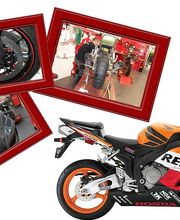 Motorrad mit Repsol-Design und vier kleine Bilder von Werkstattarbeiten in roten Rahmen.