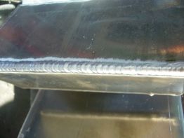 Nahaufnahme einer glatten Schweißnaht auf metallischer Oberfläche.