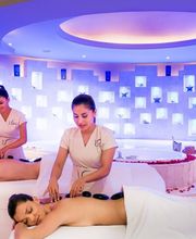 Personas recibiendo masaje en spa, ambiente relajante con iluminación suave y decoración moderna.