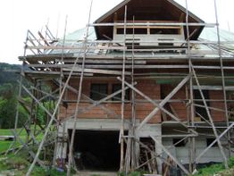 Ein Haus im Bau mit Holzgerüst umgeben.