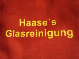 Roter Hintergrund mit gelber Schrift: „Haase’s Glasreinigung“.