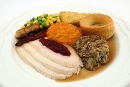 Festliches Tellergericht mit Truthahn, Gemüse, Kroketten, Yorkshire-Pudding und Soße.
