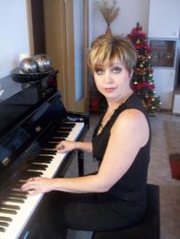 Frau mit kurzem Haar spielt Klavier, im Hintergrund ein geschmückter Weihnachtsbaum.