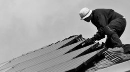 Worker installing solar panels on a roof.