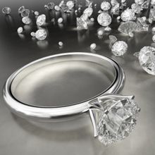 Diamond ring on a reflective surface surrounded by scattered loose diamonds.