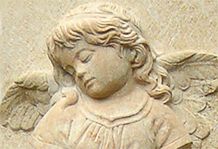 Steinerner Engel mit geschlossenen Augen und Flügeln, sanftes, ruhiges Gesicht.