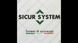 Logo "Sicur System" con testo "Sistemi di sicurezza". Linee sullo sfondo, scritta tricolore.