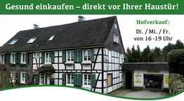 Fachwerkhaus mit Text "Gesund einkaufen" und Hofverkauf-Zeiten: Di/Mi/Fr, 16-19 Uhr.