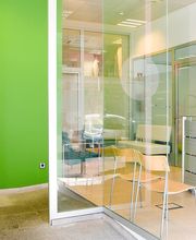 Oficina moderna con pared verde "Comprometidos con tu salud" y muebles minimalistas.