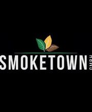 Logo mit drei Blättern in Grün, Gelb und Braun über dem Schriftzug "SMOKETOWN GmbH".