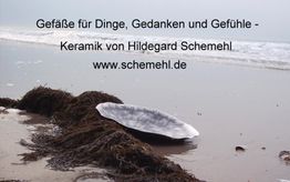 Keramikschale am Strand, mit Werbung für Schemel Keramik vor Meereshintergrund.