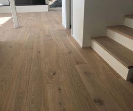 Holzfußboden mit Treppe in einem modernen Raum. Helles, minimalistisches Design.