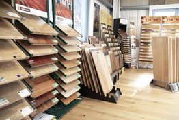 Display of various wood flooring samples in a store, showing diverse textures and shades.