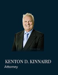Man in suit and tie smiling against dark background. Text: Kenton D. Kinnaird, Attorney.