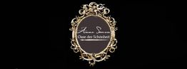 Ornater goldener Spiegelrahmen auf schwarzem Hintergrund, mit Schrift "Oase der Schönheit" innen.
