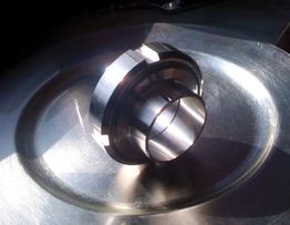 Metallteil auf einem Tisch mit Sonnenlicht und Schatten.