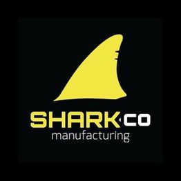 Logo with a yellow shark fin above "Shark Co Manufacturing" on a black background.