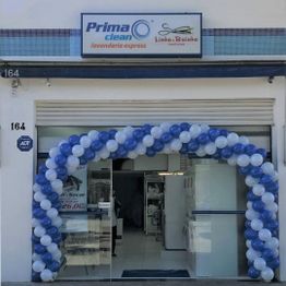 Fachada de lavanderia com arco de balões azuis e brancos na entrada.