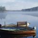 A foggy lake scene with two small boats moored to a wooden dock and trees in the background.