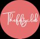 Cercle rose avec le texte "Thefiftyclub" en blanc au centre.