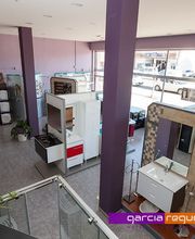 Sala de exposición de baños con muebles y lavabos modernos en un entorno amplio y bien iluminado.