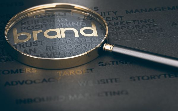 Schwarzer matter Untergrund, beschriftet mit schwarzen glänzenden Brandbuilding Begriffen. Das Keyword Brand steht in Gold im Mittelpunkt.