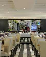 Restaurante elegante com mesas arrumadas e decoração moderna em tons neutros.