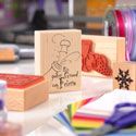 Stempel auf einem Tisch mit Bastelutensilien im Hintergrund.