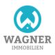 Logo von Wagner Immobilien mit blauem Kreis und weißem Haus. Text: Wagner Immobilien.