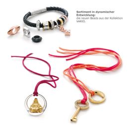 Schmuckkollektion mit Armband, Ringen und Anhängern in Rot- und Goldtönen auf weißem Hintergrund.