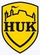 Gelbes Wappen mit schwarzem Text "HUK" und stilisiertem Burgturm.